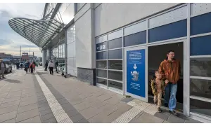 Ojciec z synem wchodzą do Podziemnych Tras Szczecina. Na zewnątrz ruchliwy rynek Szczecin.