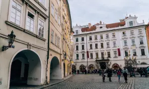 Urokliwy plac w stolicy Czech, z brukowaną nawierzchnią i zabytkowymi kamienicami.