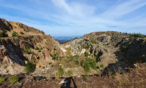 Krajobraz po wydobyciu kwarcu w kopalni Stanisław. Skarpy skalne i zieleń tworzą surowy, ale piękny widok.