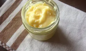 Domowy aioli w słoiczku, kremowy i puszysty, gotowy do podania z ulubionymi potrawami.