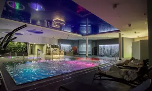 Relaks w hotelowym spa w Wielkopolsce. Basen z kolorowym podświetleniem, wodospady i leżaki.