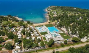 Idealne miejsce, gdzie na wakacje z dziećmi: kompleks basenów, plaża i domki w otoczeniu zieleni.