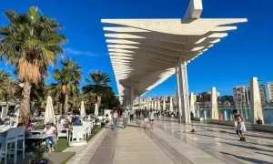 Spacerem po Muelle Uno w Maladze, gdzie zobaczyć można nowoczesną architekturę i palmy.
