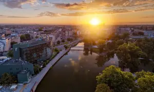 Zachód słońca nad Odrą we Wrocławiu, idealny na city break. Widok na Park Plaza i malownicze kamienice.
