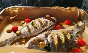 Dwie dorady pieczone z cytryną, czosnkiem i pomidorkami. Dorada co to za ryba? Pyszna ryba prosto z pieca!