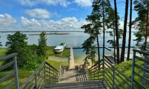 Schody prowadzą do jeziora, gdzie cumuje statek. To widok, który mówi "gdzie są Mazury".