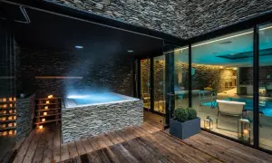 Luksusowy wrocław hotel z basenem i jacuzzi na zewnątrz. Kamienne wykończenia, drewniany taras i nastrojowe oświetlenie tworzą relaksującą atmosferę.