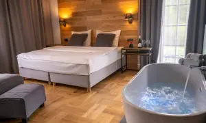 Przytulny pokój w hotelu w Bieszczadach z wanną z hydromasażem i wygodnym łóżkiem.