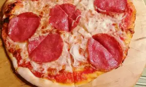 Pizza z pepperoni i cebulą, zrumieniona skórka, roztopiony ser.