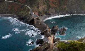 Kamienna ścieżka prowadzi do samotnej chatki na klifie w Euskadi, otoczona wzburzonym morzem i skalistymi brzegami.