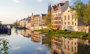 Nad rzeką w Opolu, w blasku słońca, odbijają się zabytkowe kamienice. To jedno z magicznych miejsc opolskich, gdzie historia spotyka się z naturą.