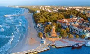 Widok na nadmorskie miasteczko z latarnią morską, plażą i molo. Idealne miejsce, gdzie nad morze.
