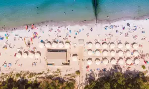 Idealne miejsce na wakacje: plaża z parasolami i ludźmi, idealna dla szukających najlepszych hoteli nad morzem z pełnym wyżywieniem.