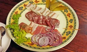 Talerz z wędlinami, słoniną, ogórkami i cebulą. Idealne danie, by dowiedzieć się, co zjeść w Wilnie.
