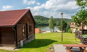 Drewniany domek nad jeziorem Śląsk, z placem zabaw i widokiem na las. Idealne miejsce na wypoczynek.