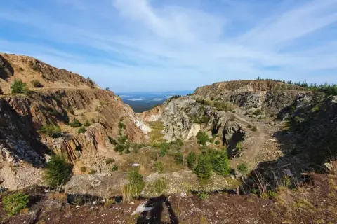 Krajobraz po wydobyciu kwarcu w kopalni Stanisław. Skarpy skalne i zieleń tworzą surowy, ale piękny widok.