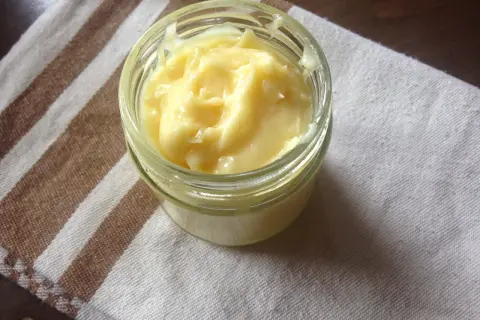 Domowy aioli w słoiczku, kremowy i puszysty, gotowy do podania z ulubionymi potrawami.