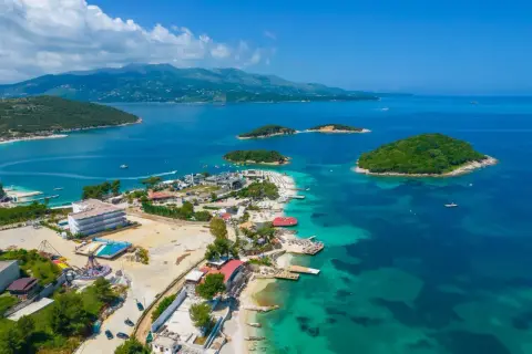 Rajska plaża z wysepkami, idealne miejsce na albania wakacje. Turkusowa woda, zielone wzgórza i słońce.