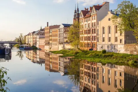 Nad rzeką w Opolu, w blasku słońca, odbijają się zabytkowe kamienice. To jedno z magicznych miejsc opolskich, gdzie historia spotyka się z naturą.