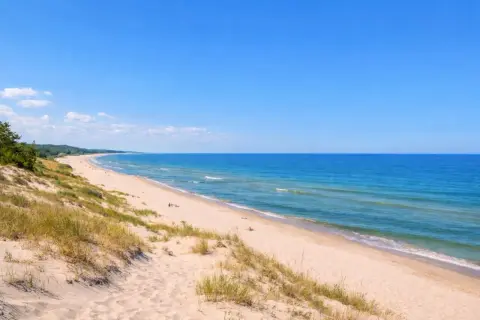 Piękna plaża nad Bałtykiem, z wydmami porośniętymi trawą. Ciekawe morze bałtyckie oferuje wiele atrakcji.