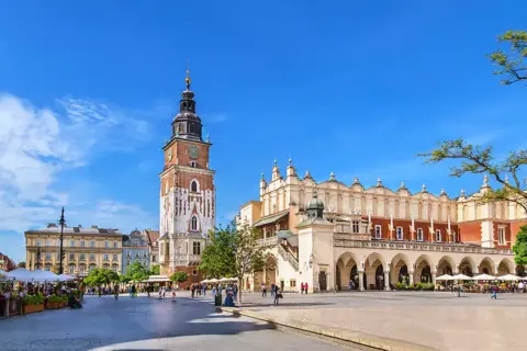 Rynek Główny w Krakowie, z Sukiennicami i wieżą Ratuszową, tętni życiem. Stare miasto w Krakowie zachwyca architekturą i atmosferą.