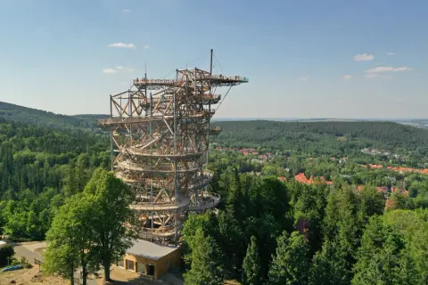 Wieża widokowa w Szklarskiej Porębie, przypominająca spiralny deptak, wznosi się nad zielonymi lasami i miastem.
