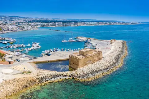 Zamek w Pafos nad turkusowym morzem, pełnym łodzi. Wybór między Pafos a Larnaką? To miejsce jest piękne!