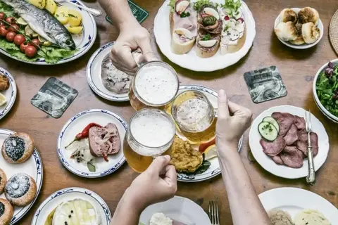 Uczta w stylu kuchnia czeska: ryba, kiełbasa, sery, piwo i przekąski.