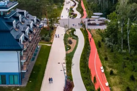 Nowoczesna promenada w Świnoujściu oferuje liczne atrakcje: ścieżki spacerowe, rowerowe i biegowe, a także malownicze widoki na otaczającą zieleń i nowoczesną architekturę.