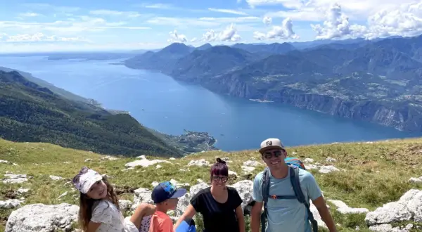 Rodzina z psem cieszy się widokiem na jezioro Garda z Monte Baldo.