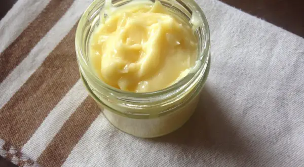 Domowy aioli w słoiczku, kremowy i puszysty, gotowy do podania z ulubionymi potrawami.