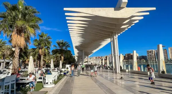 Spacerem po Muelle Uno w Maladze, gdzie zobaczyć można nowoczesną architekturę i palmy.