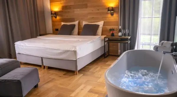 Przytulny pokój w hotelu w Bieszczadach z wanną z hydromasażem i wygodnym łóżkiem.