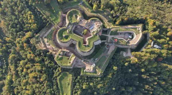 Fortyfikacje w kształcie gwiazdy otoczone lasem. Srebrna Góra oferuje unikalne atrakcje historyczne i widoki.