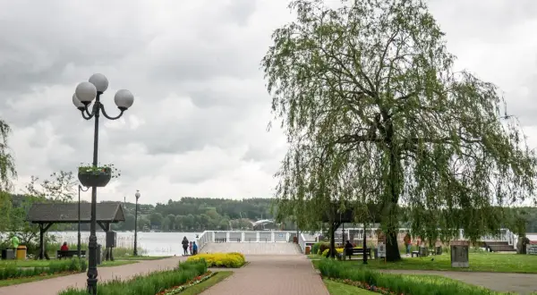 Spacer po deptaku w Mrągowie. Wierzba płacząca i latarnia przy ścieżce prowadzącej nad jezioro.
