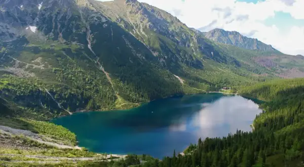 Malownicze Morskie Oko otoczone górami i lasem. Spacer do niego to piękna przygoda.