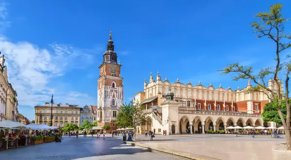 Rynek Główny w Krakowie, z Sukiennicami i wieżą Ratuszową, tętni życiem. Stare miasto w Krakowie zachwyca architekturą i atmosferą.
