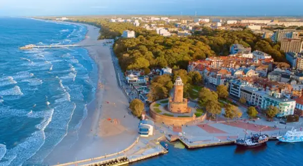 Widok na latarnię morską i plażę w jednym z nadmorskich miast w Polsce.