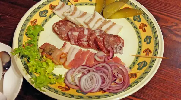 Talerz z wędlinami, słoniną, ogórkami i cebulą. Idealne danie, by dowiedzieć się, co zjeść w Wilnie.