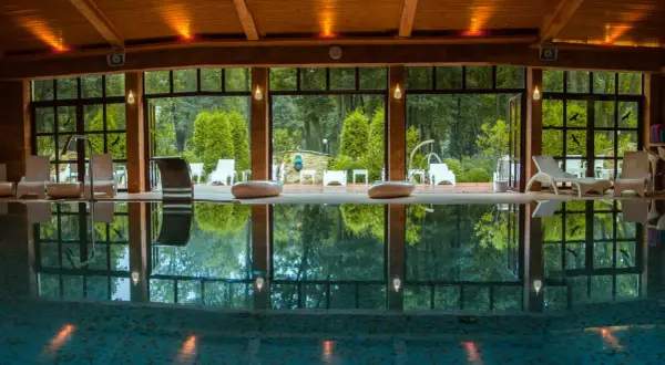 Relaks w hotelu spa lubelskie. Basen z leżakami i widokiem na ogród.