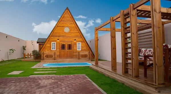 Urocze domki nad morzem blisko plaży, z basenem i drewnianą altaną. Idealne miejsce na wypoczynek.