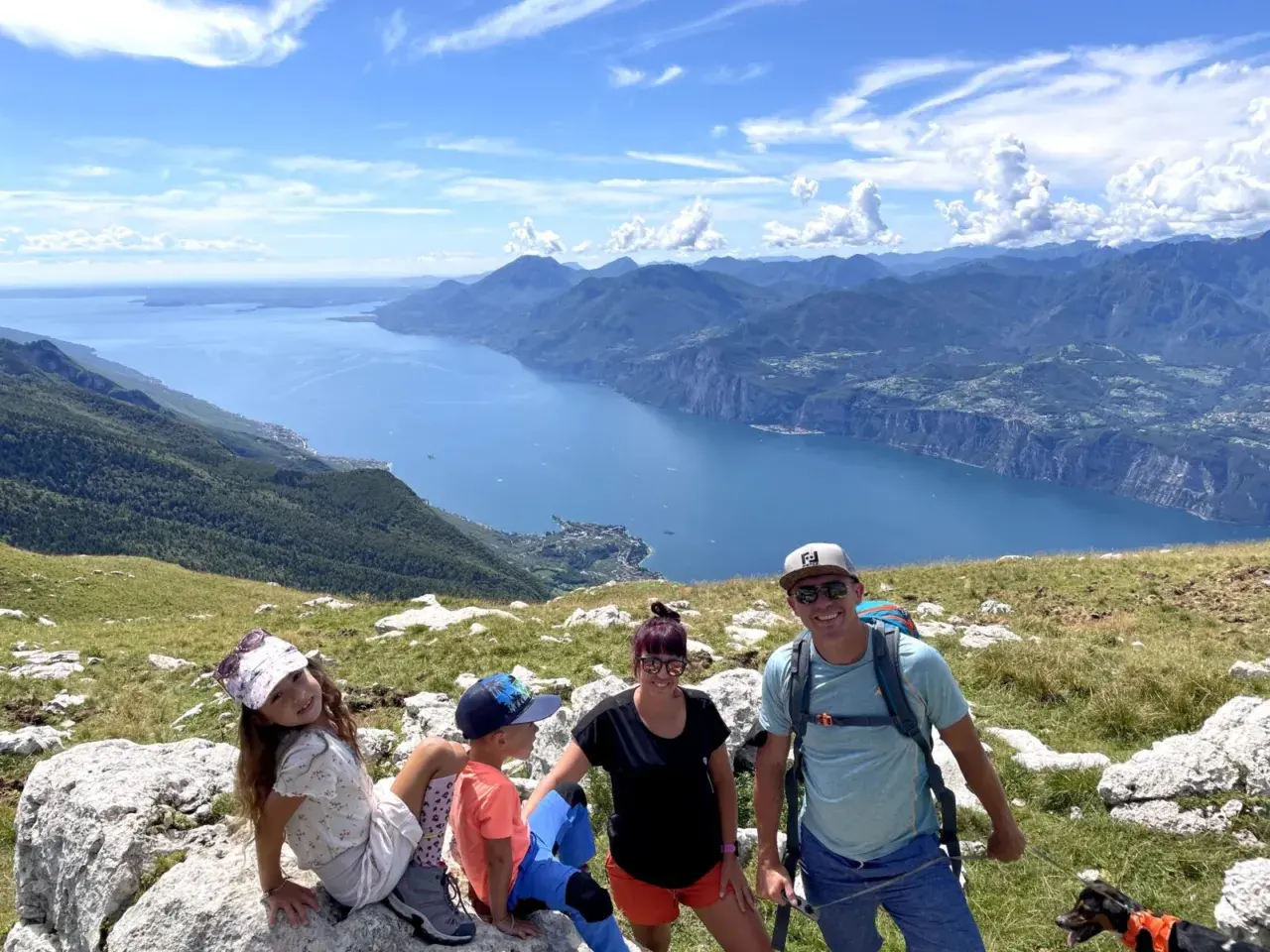 Rodzina z psem cieszy się widokiem na jezioro Garda z Monte Baldo.