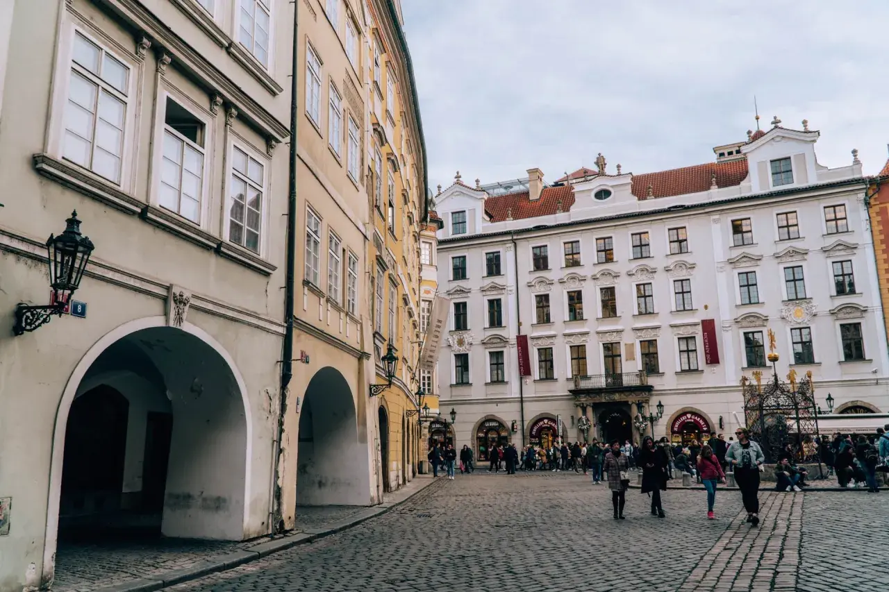 Urokliwy plac w stolicy Czech, z brukowaną nawierzchnią i zabytkowymi kamienicami.