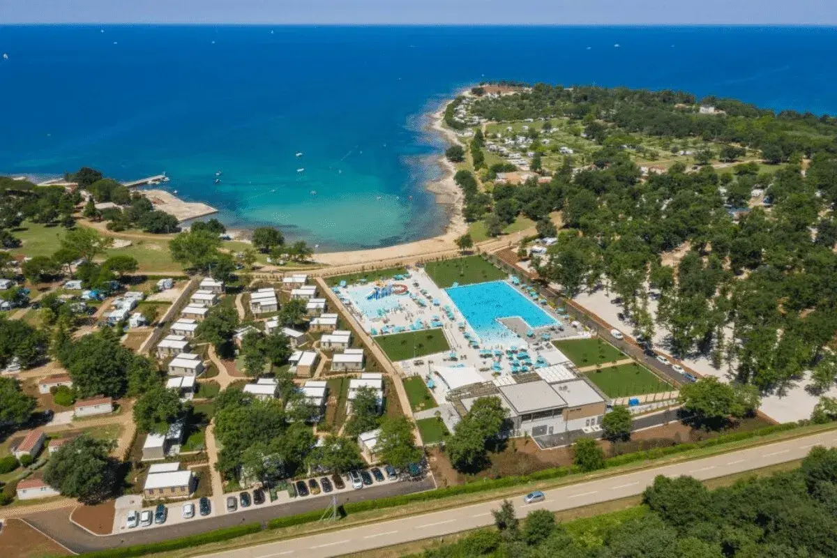 Idealne miejsce, gdzie na wakacje z dziećmi: kompleks basenów, plaża i domki w otoczeniu zieleni.