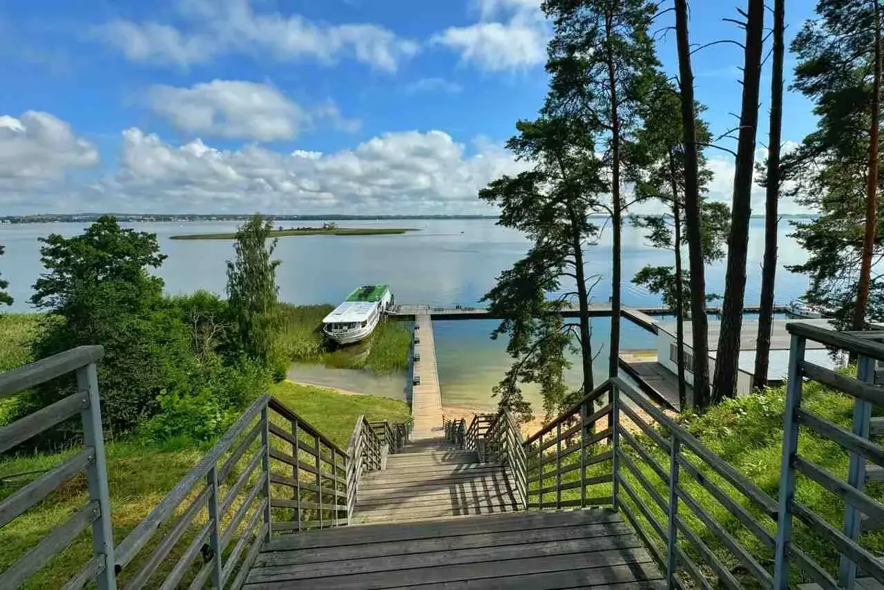 Schody prowadzą do jeziora, gdzie cumuje statek. To widok, który mówi "gdzie są Mazury".