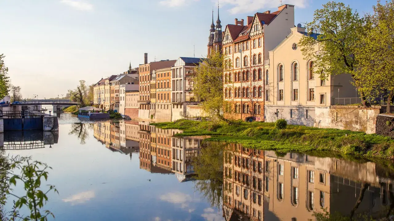 Nad rzeką w Opolu, w blasku słońca, odbijają się zabytkowe kamienice. To jedno z magicznych miejsc opolskich, gdzie historia spotyka się z naturą.