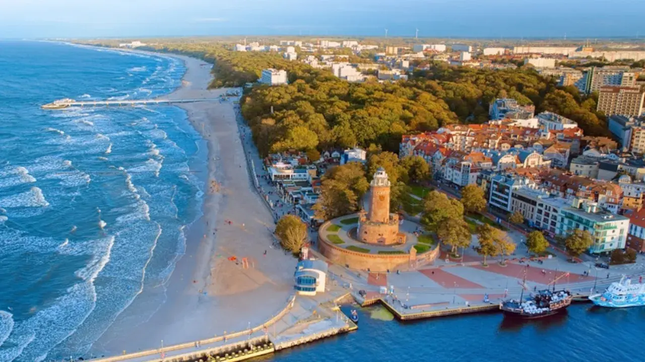 Widok na latarnię morską i plażę w jednym z nadmorskich miast w Polsce.