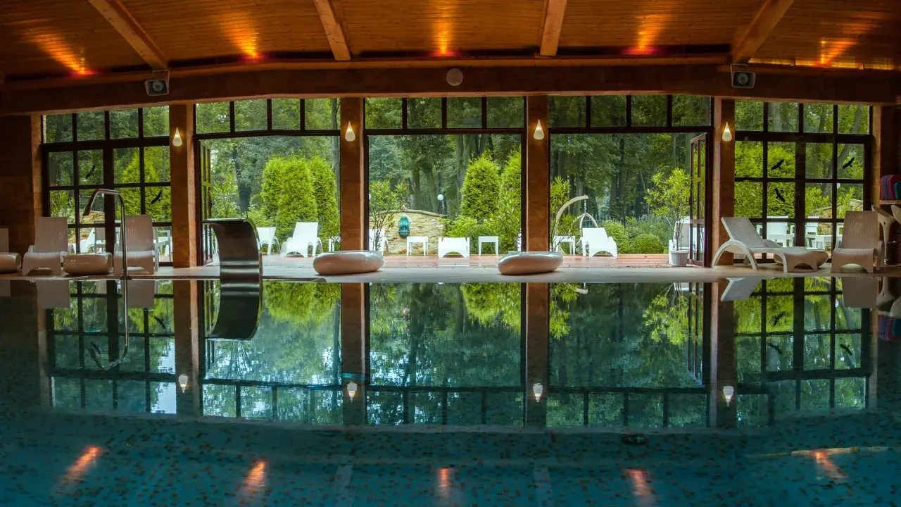 Relaks w hotelu spa lubelskie. Basen z leżakami i widokiem na ogród.