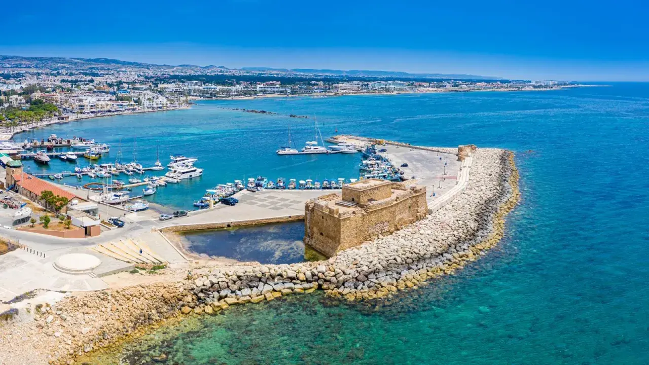 Zamek w Pafos nad turkusowym morzem, pełnym łodzi. Wybór między Pafos a Larnaką? To miejsce jest piękne!