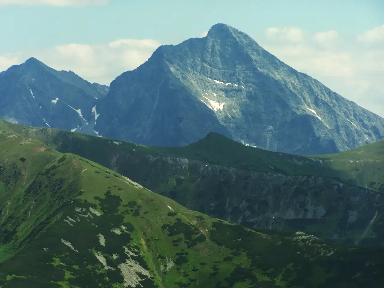 Majestatyczny szczyt w Tatrach Wysokich, 2494 m, góruje nad zielonymi zboczami.